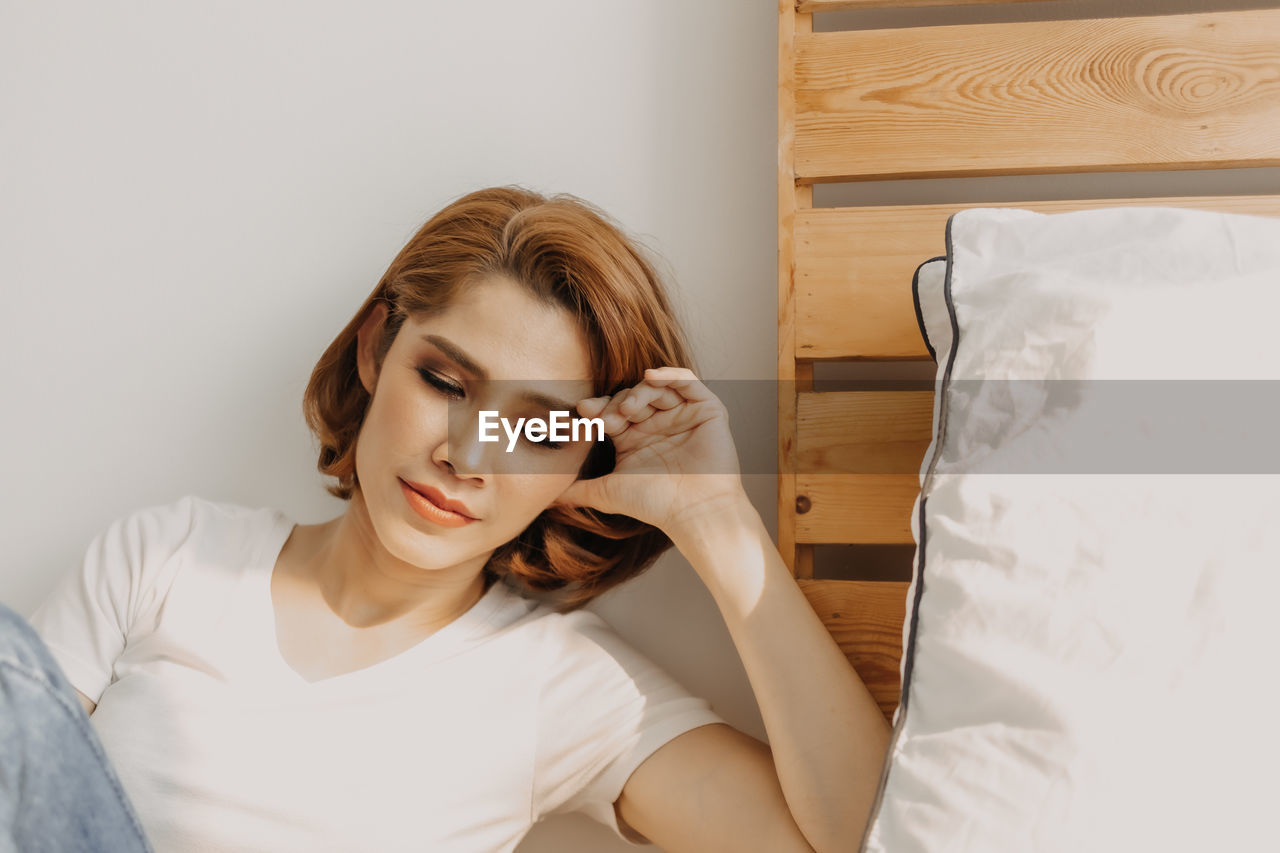 Portrait of young woman relaxing on bed