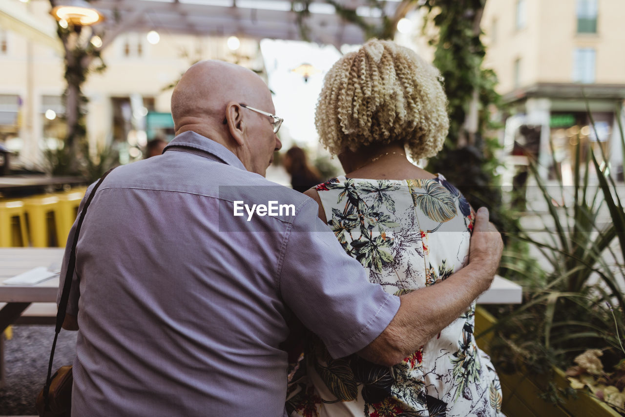 Rear view of senior couple sitting in cafe during vacation