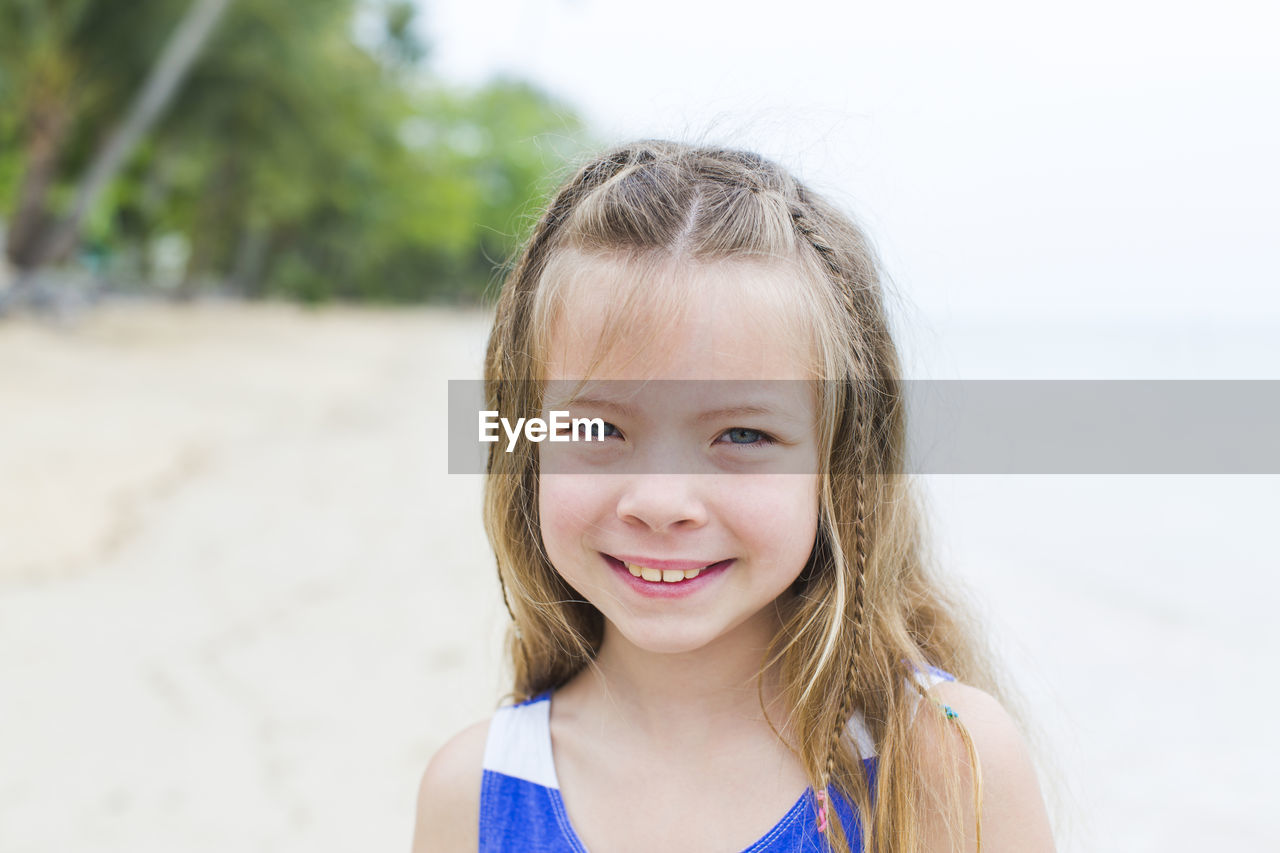 Close-up portrait of smiling girl at beach