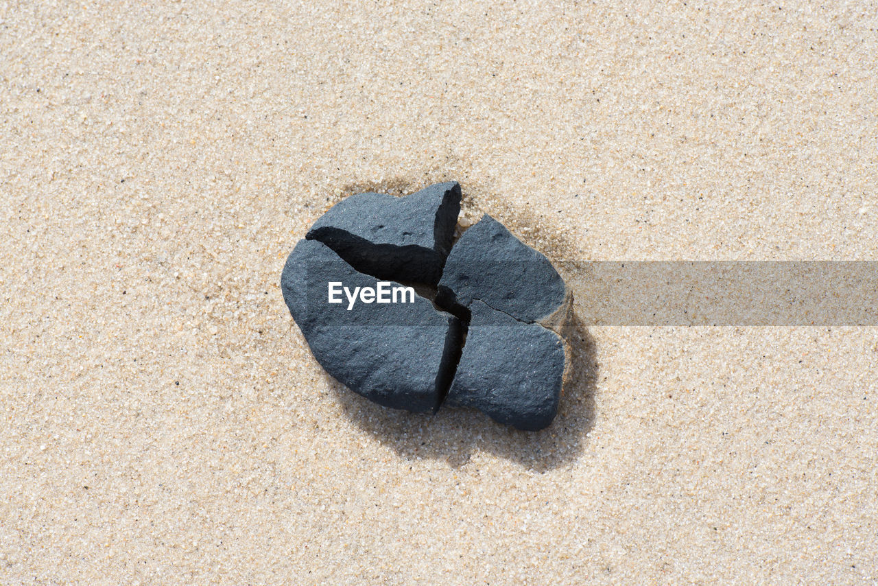 High angle view of broken rock on sand