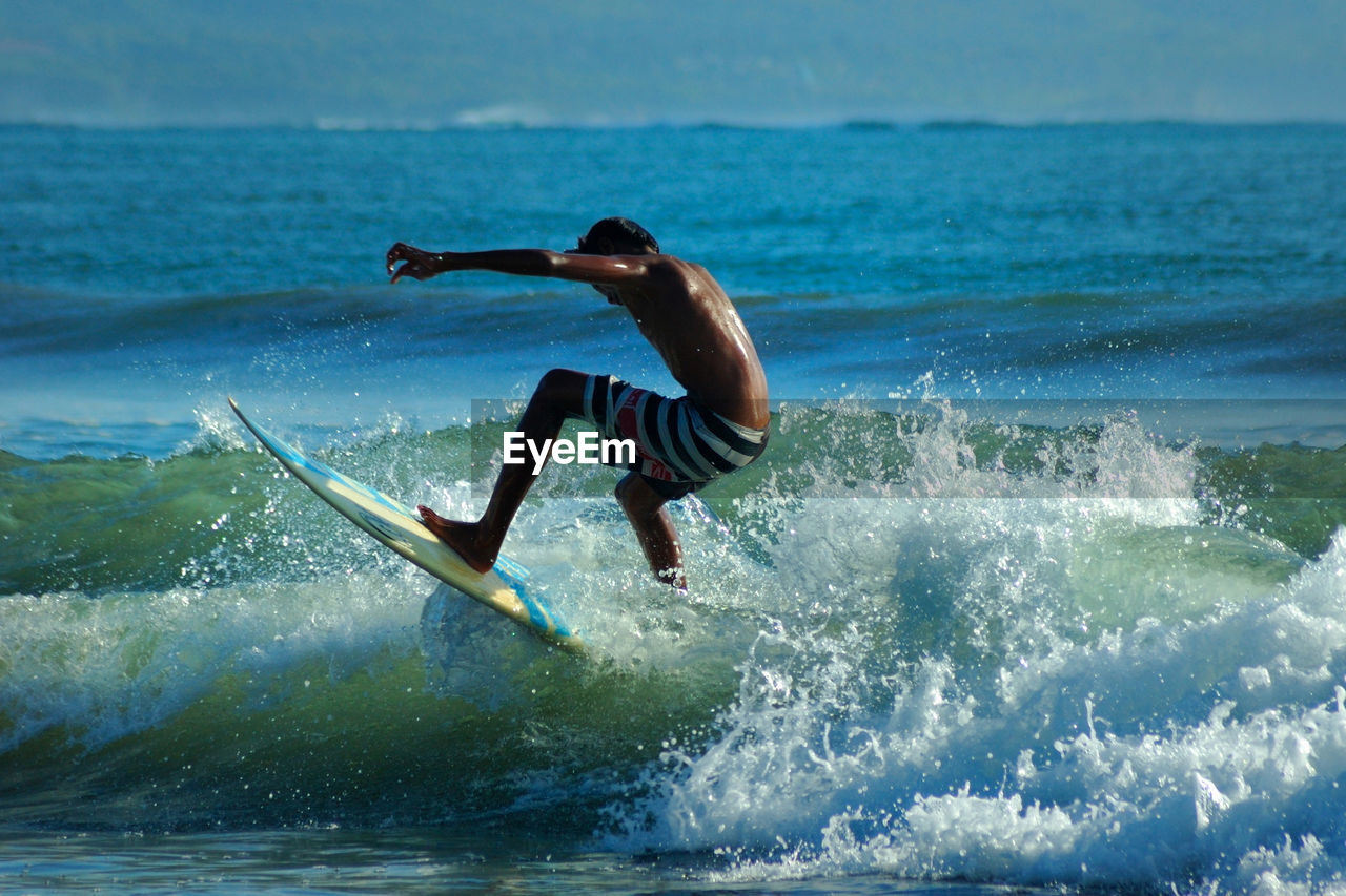 MAN SURFING ON SEA