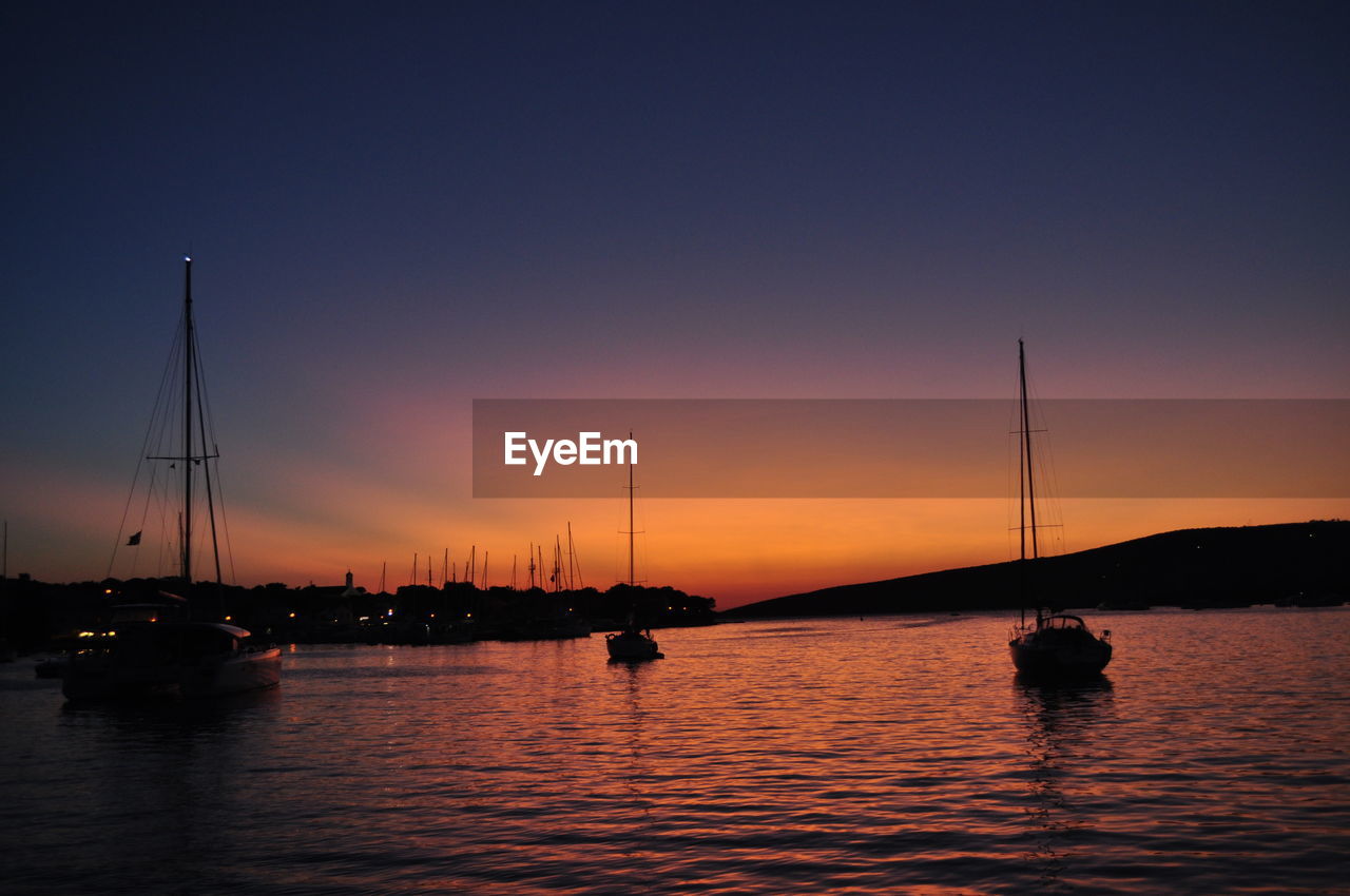 Sailboats in marina at sunset