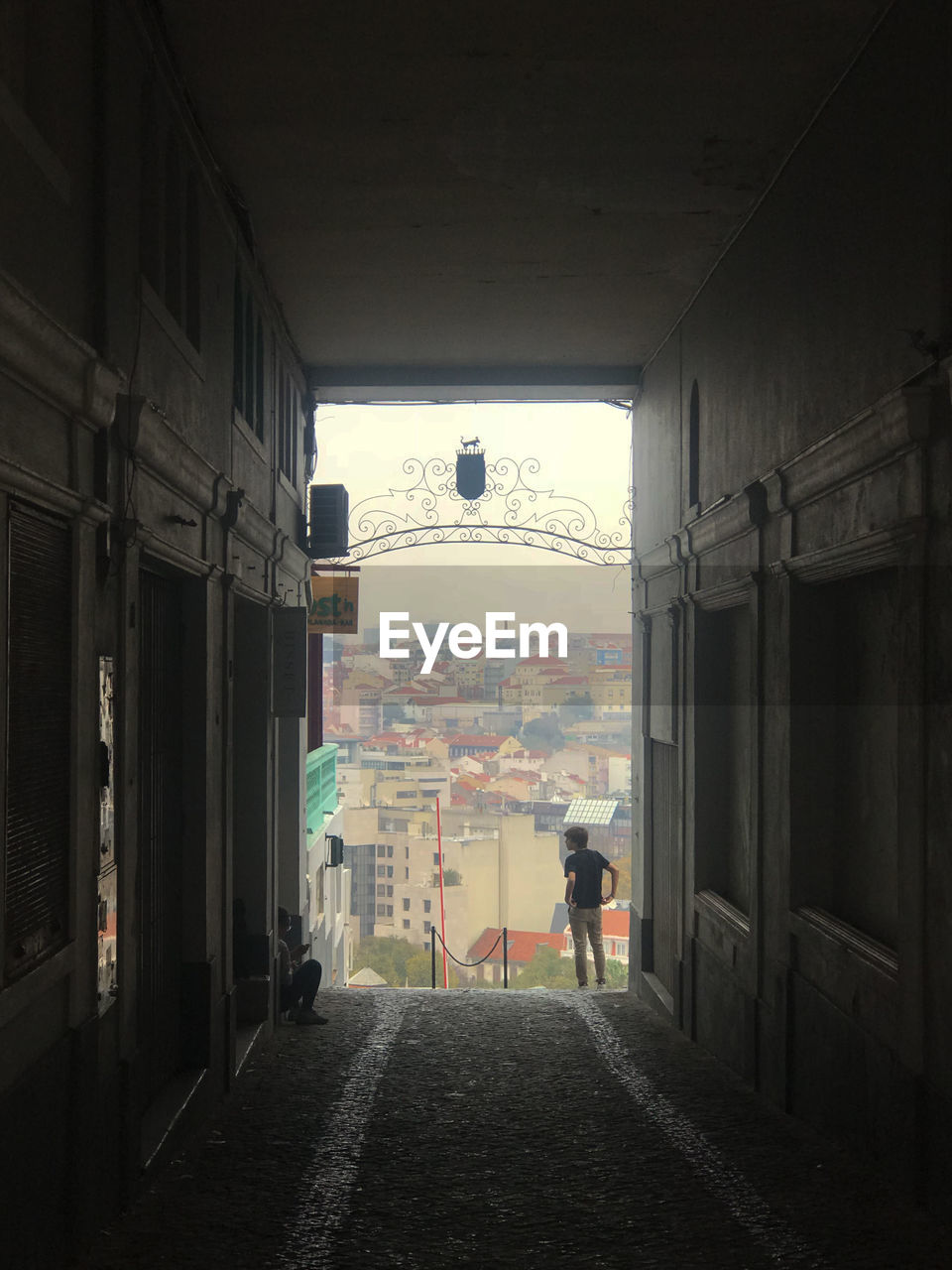 REAR VIEW OF PEOPLE WALKING IN CORRIDOR