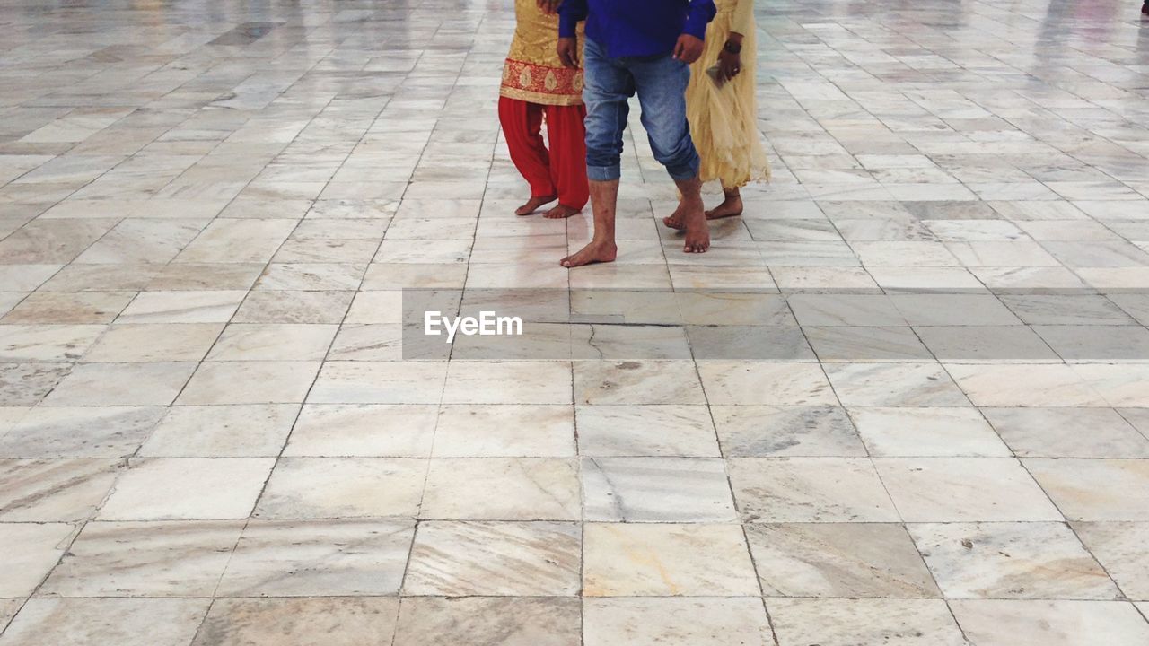 LOW SECTION OF WOMAN WALKING ON FLOORING