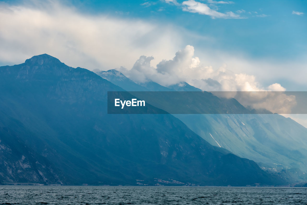 Scenic view of sea and mountains against sky