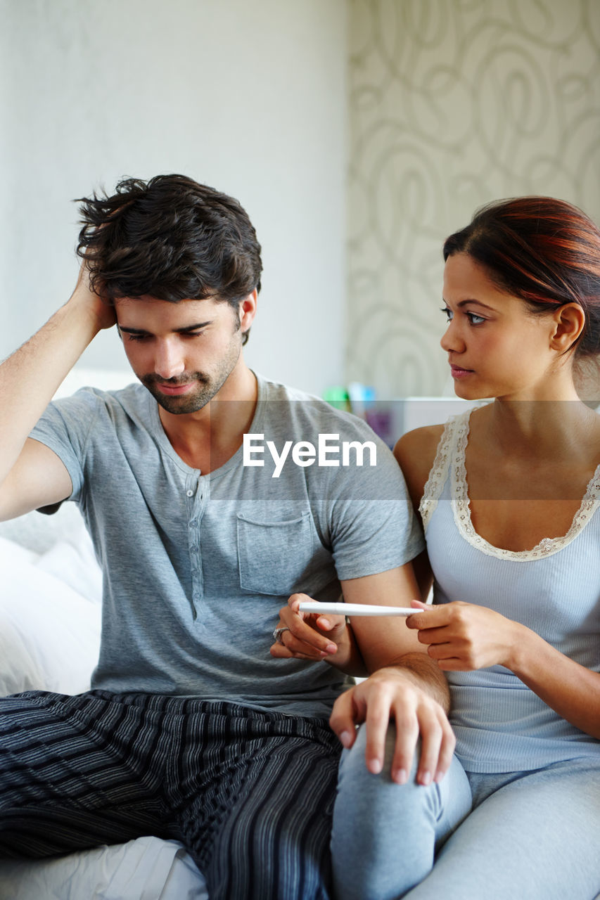 side view of mother and daughter using laptop while sitting at home