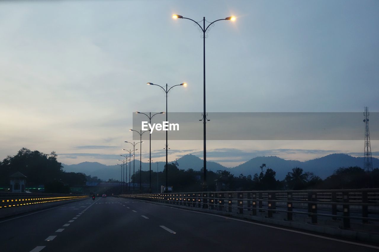 Empty road against cloudy sky