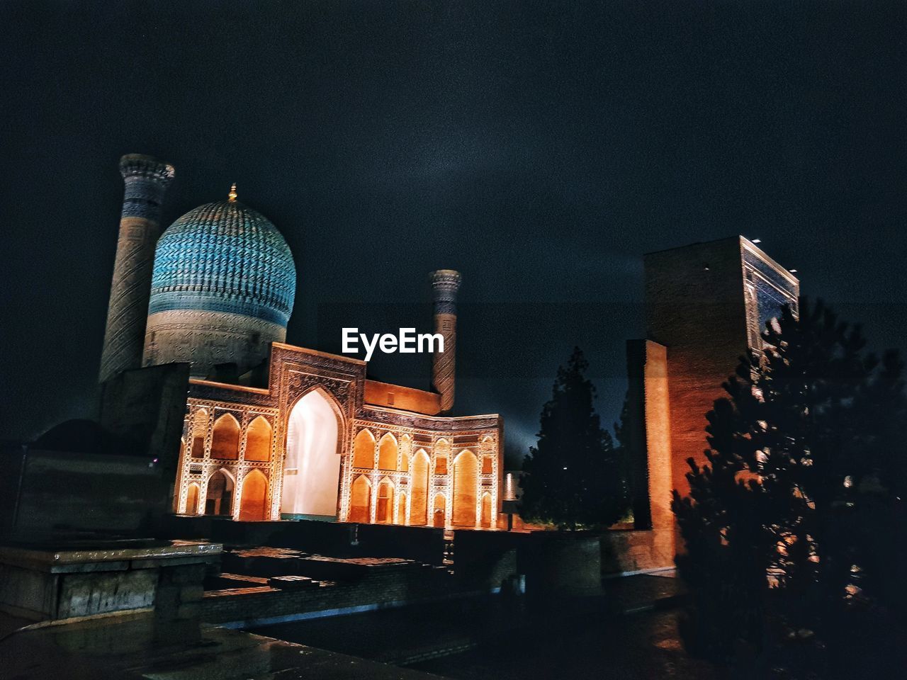 Low angle view of illuminated mosque in city at night