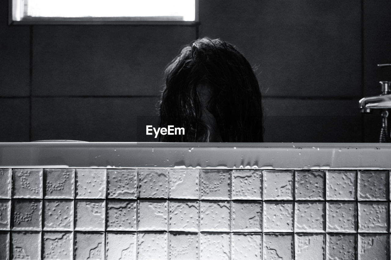 Woman peeking out of bath