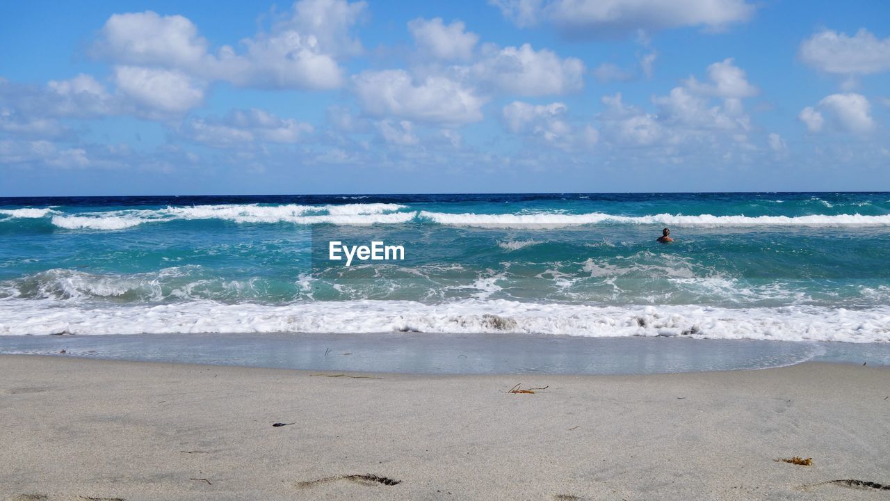 Person in sea against sky