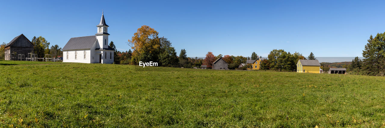 Panoramic view of church on field against clear sky