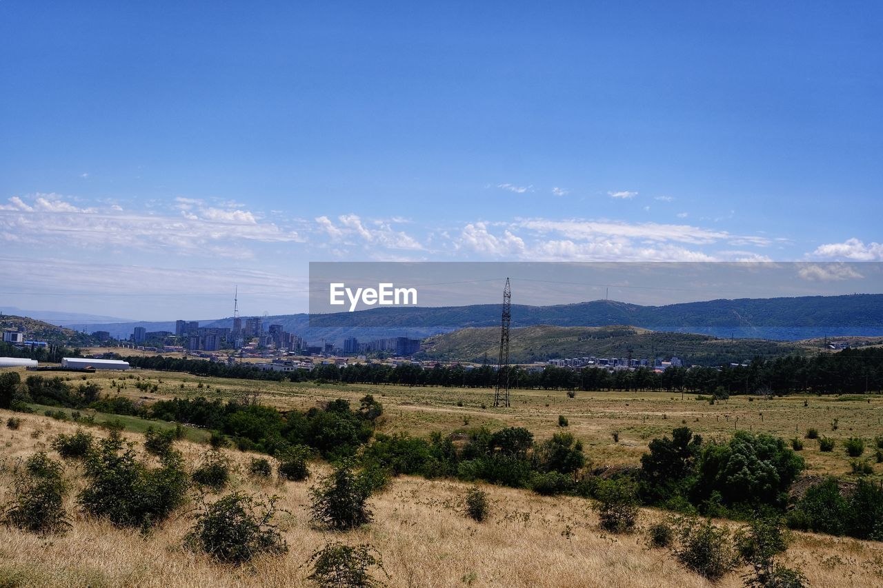 landscape, environment, sky, scenics - nature, hill, nature, land, horizon, plant, beauty in nature, rural area, blue, no people, tranquility, tranquil scene, natural environment, field, cloud, plain, tree, non-urban scene, travel destinations, travel, mountain range, outdoors, rural scene, day, architecture, tourism, grass, agriculture, semi-arid, plateau, sunlight, remote