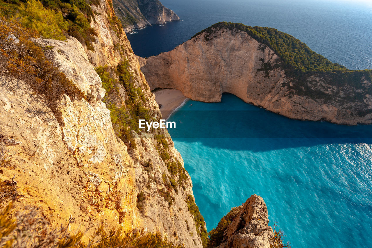 HIGH ANGLE VIEW OF ROCKS ON SEA