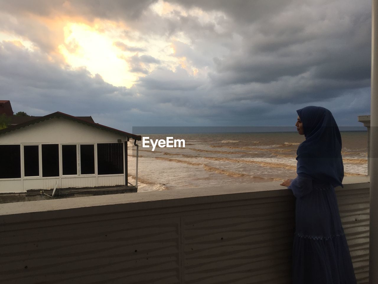 SIDE VIEW OF WOMAN STANDING ON BEACH