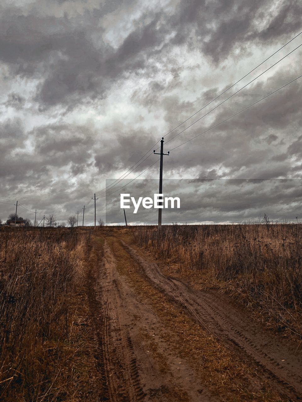 sky, cloud, field, horizon, environment, soil, landscape, nature, land, rural area, no people, prairie, electricity, power generation, technology, road, electricity pylon, wind, scenics - nature, rural scene, transportation, outdoors, non-urban scene, beauty in nature, tranquility, day, morning, overcast, power supply, cable, dirt, plant, dirt road, plain, tranquil scene, hill, agriculture, power line, track, horizon over land, storm