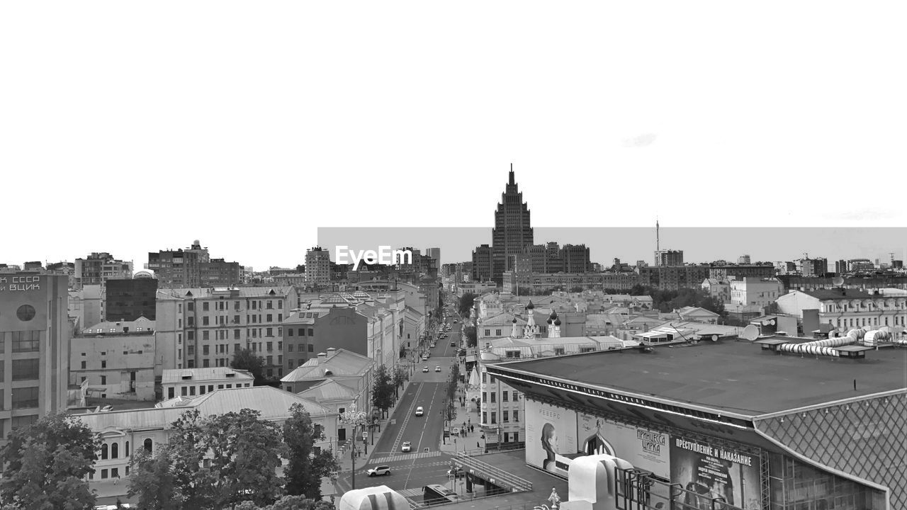 HIGH ANGLE VIEW OF CITY BUILDINGS AGAINST CLEAR SKY