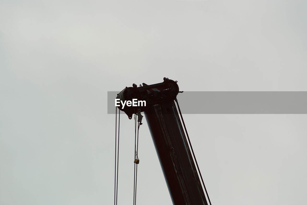 Low angle view of crane against clear sky