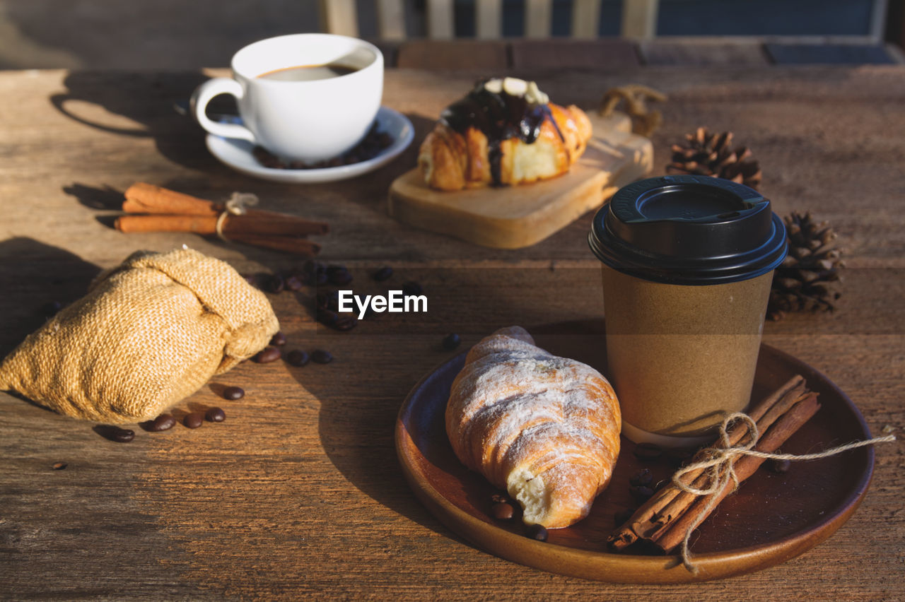 food and drink, food, cup, drink, mug, coffee, coffee cup, baked, freshness, refreshment, wood, table, no people, still life, croissant, hot drink, sweet food, rustic, bread, tableware, french food, indoors, crockery, healthy eating, breakfast, meal, nature, dessert