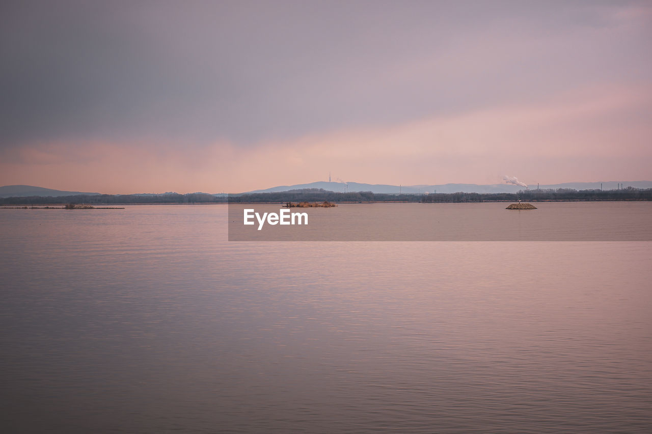 water, sky, reflection, scenics - nature, beauty in nature, sea, morning, tranquility, dawn, nature, tranquil scene, cloud, horizon, dramatic sky, environment, landscape, sunrise, travel destinations, mountain, no people, moody sky, land, outdoors, idyllic, architecture, travel, seascape, bay, copy space, tourism, body of water, atmospheric mood, coast, beach, ocean, city, shore, waterfront, horizon over water, distant, awe