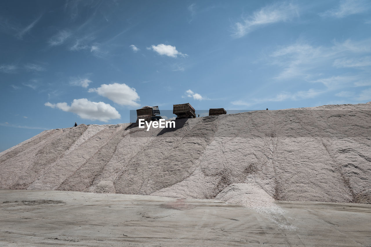 sand, sky, cloud, natural environment, nature, land, monument, landscape, environment, architecture, industry, mountain, rock, desert, plateau, geology, day, mining, blue, outdoors, no people, scenics - nature, built structure, travel, history, travel destinations