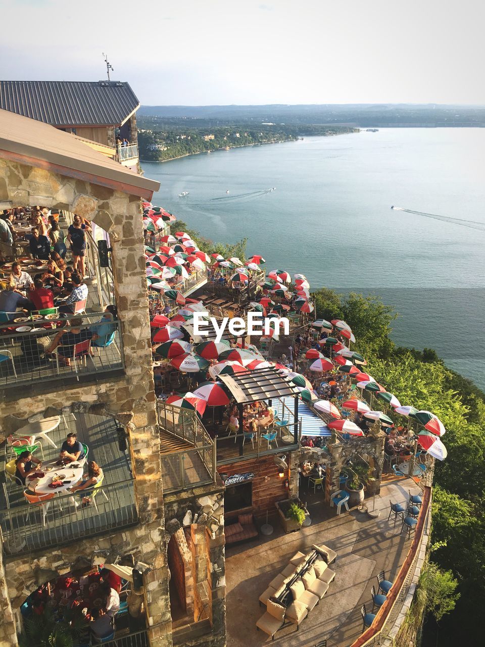 HIGH ANGLE VIEW OF PEOPLE BY SEA AGAINST SKY