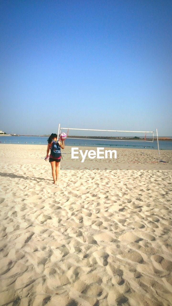 Full length of woman on beach against clear sky