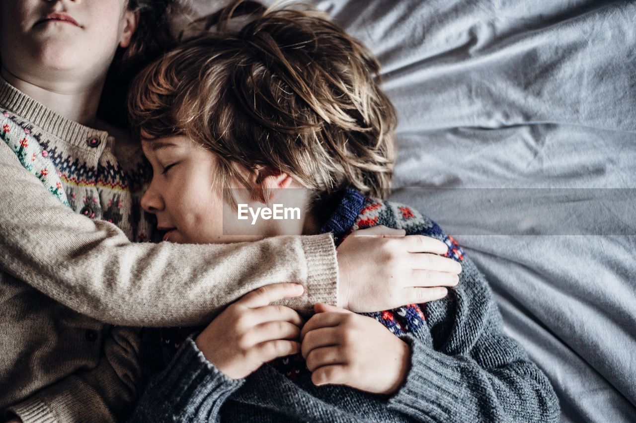 Directly above shot of children sleeping on bed at home