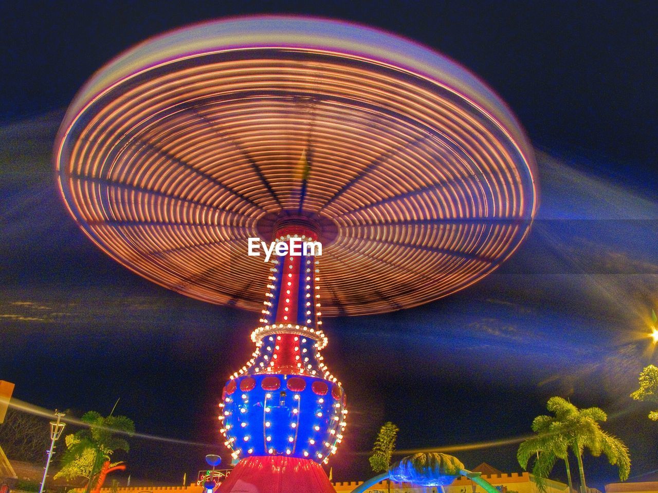 Low angle view of illuminated amusement park ride at night