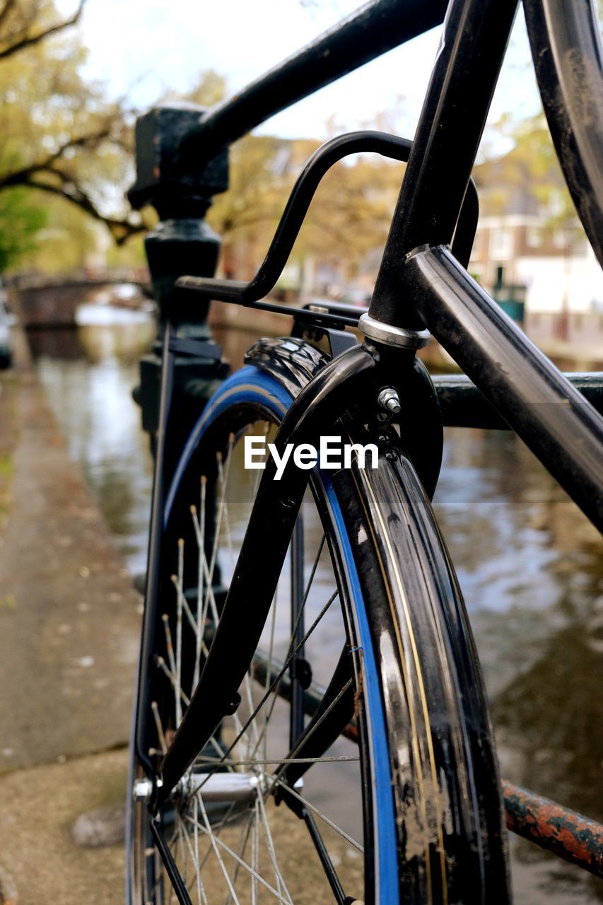 CLOSE-UP OF BICYCLE BY WATER