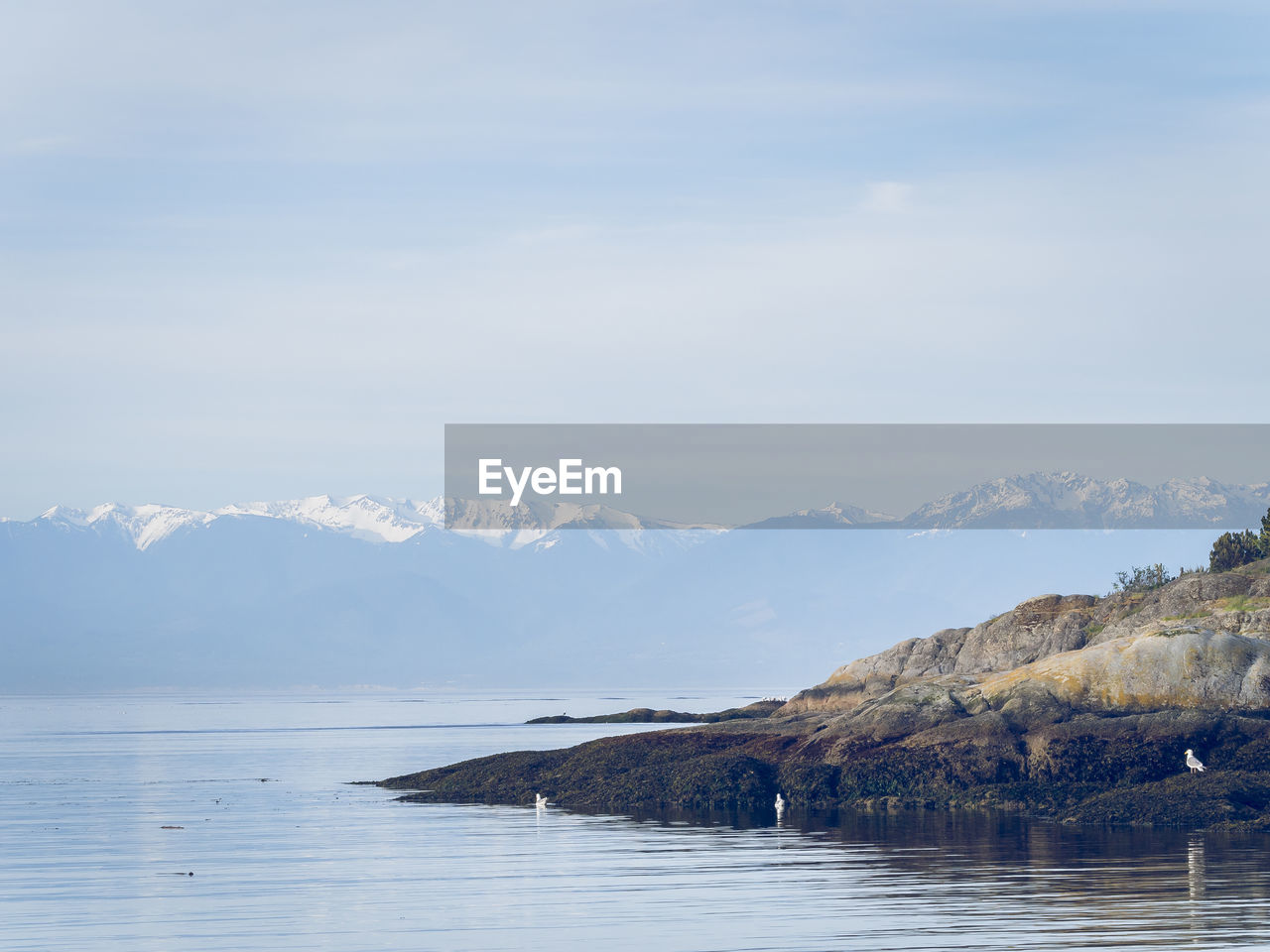 Scenic view of sea and mountains against sky