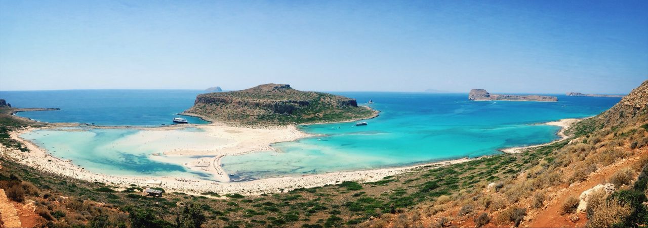 Idyllic view of island near beach against clear sky