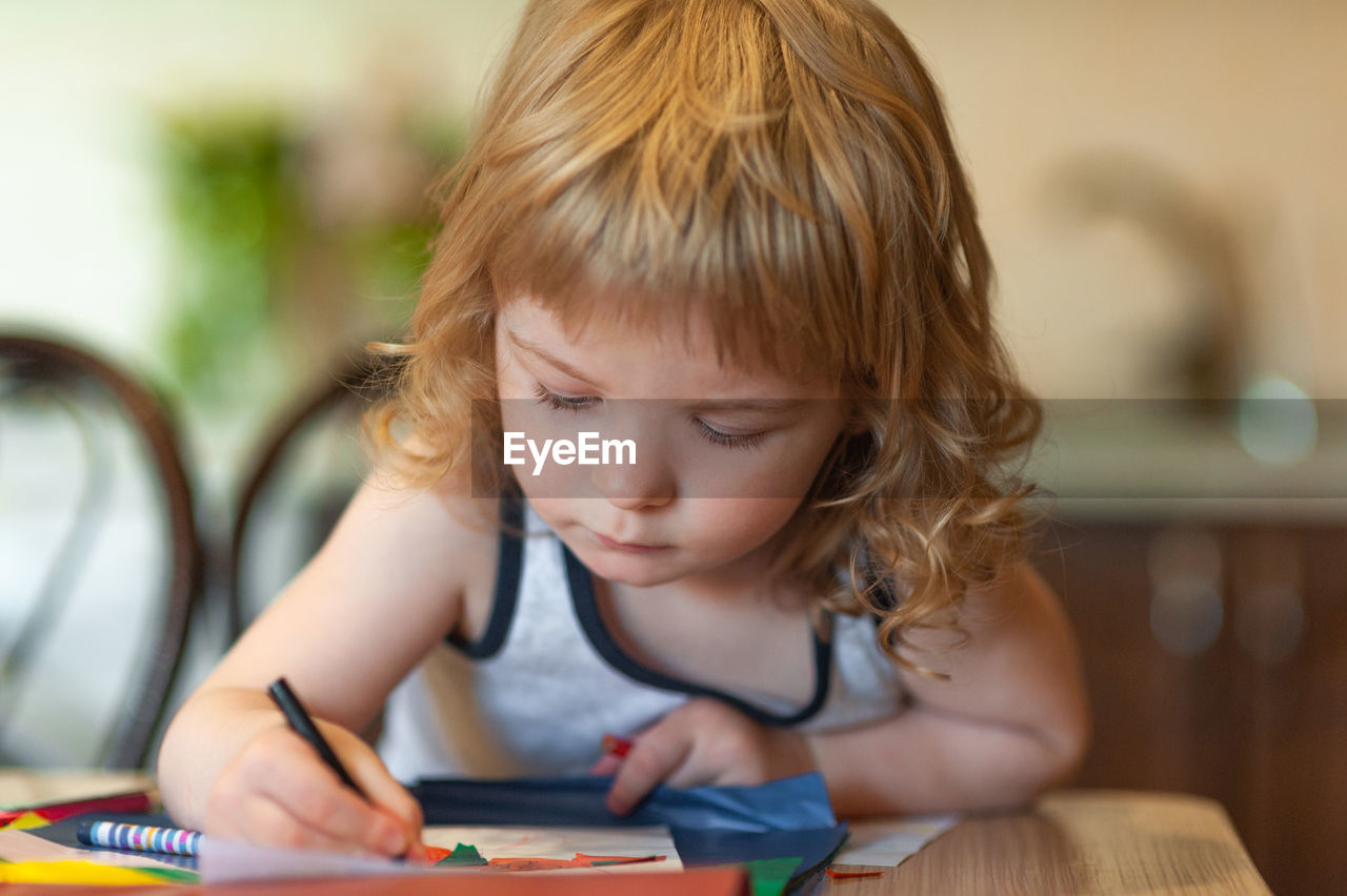 Portrait of cute baby girl on table