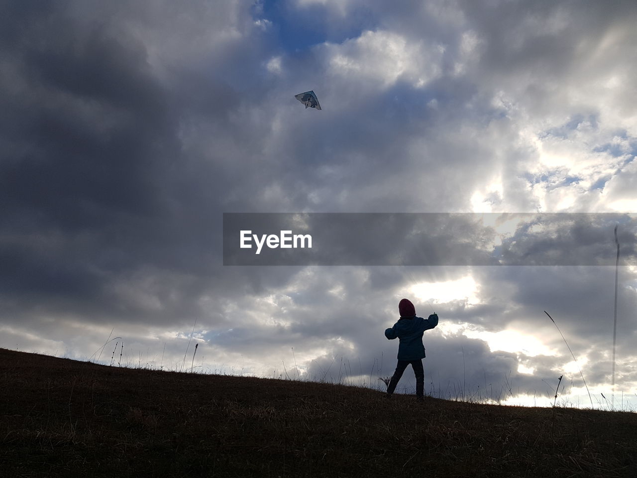 cloud, sky, horizon, one person, nature, silhouette, sunlight, wind, standing, sea, morning, adult, full length, men, leisure activity, beauty in nature, environment, land, outdoors, hill, overcast, landscape, person, dusk, flying, day, dramatic sky, bird, lifestyles, cloudscape