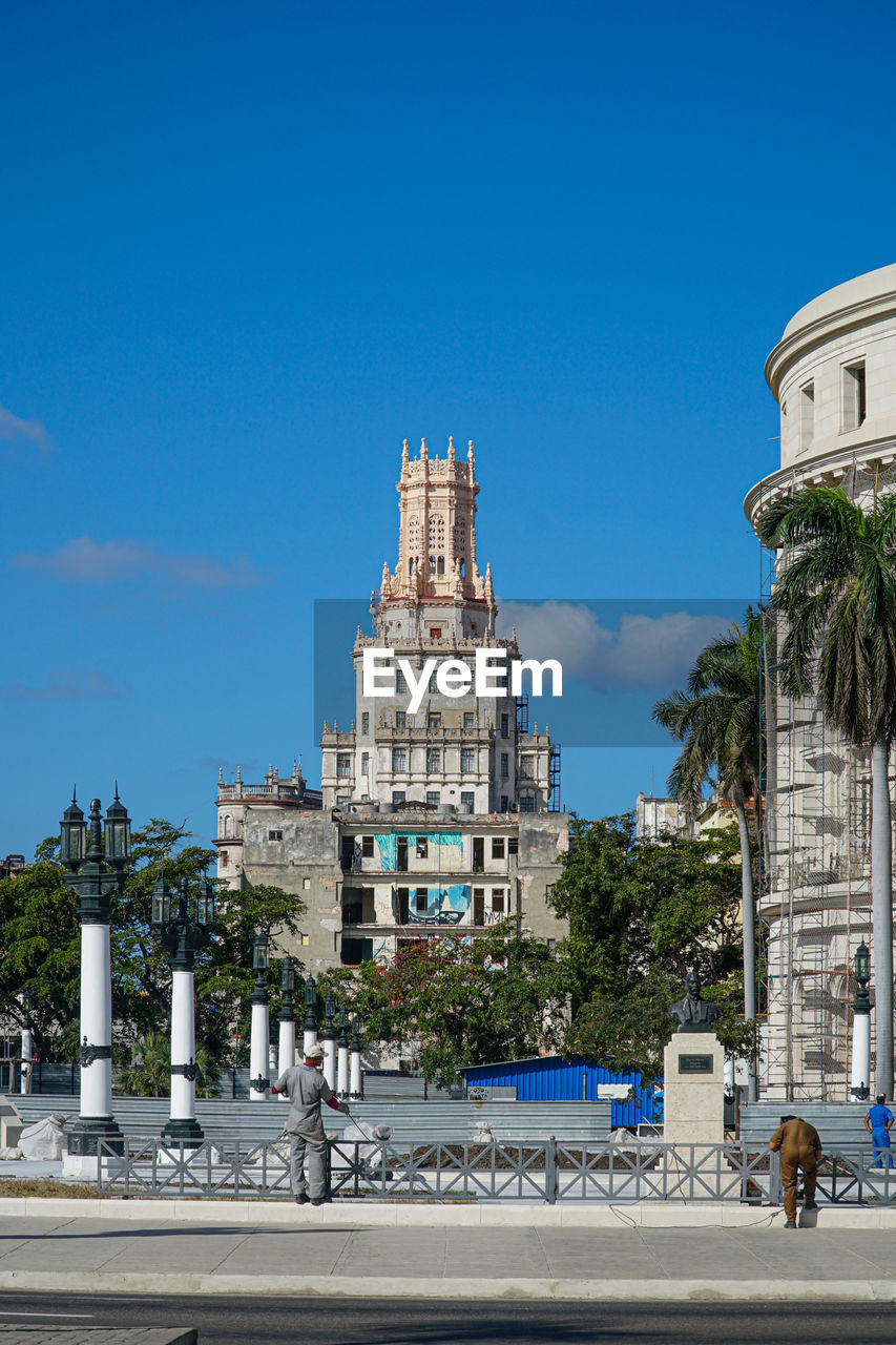 Buildings in city against clear blue sky