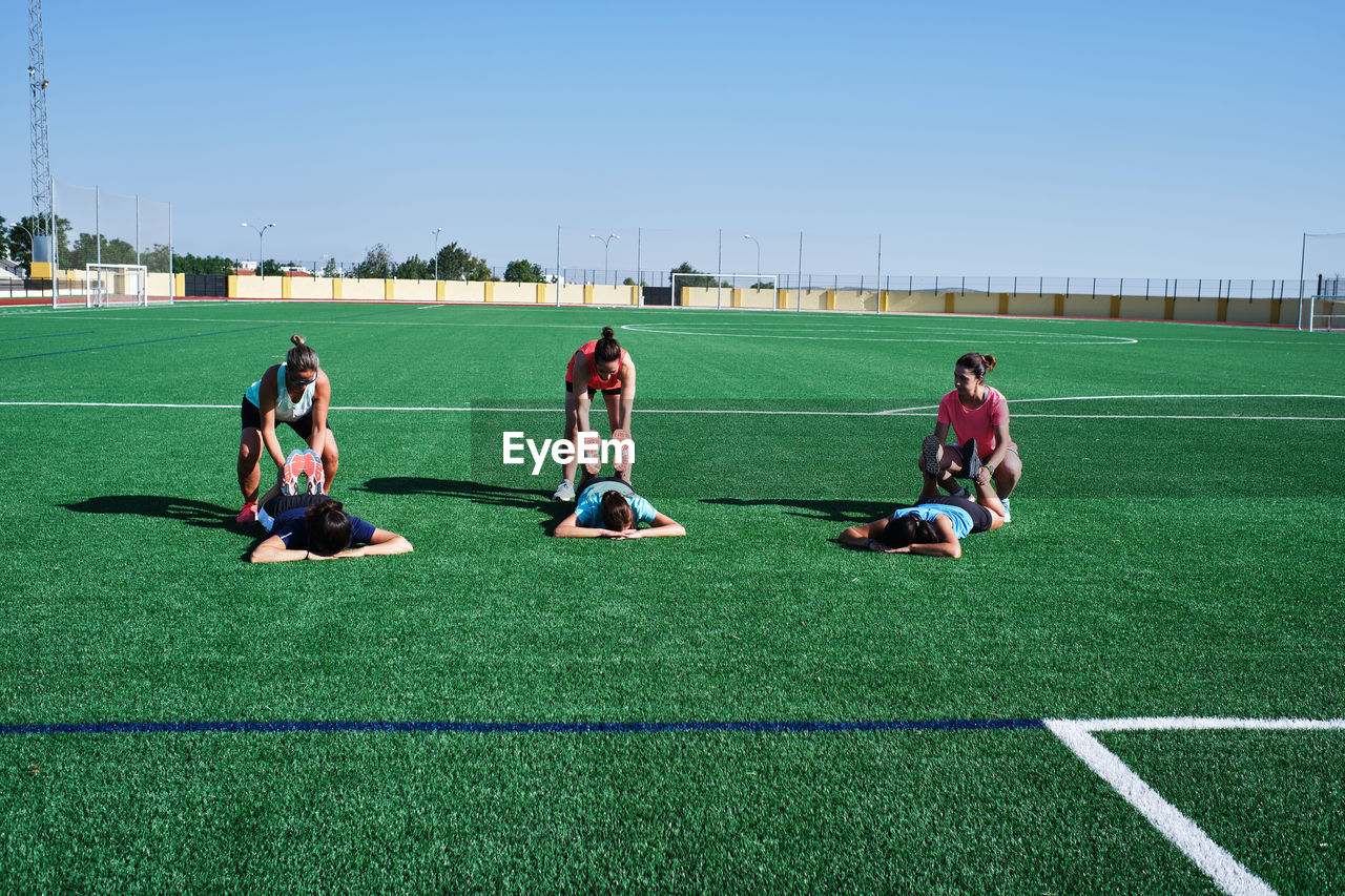 Group of young women practice stretching after their training