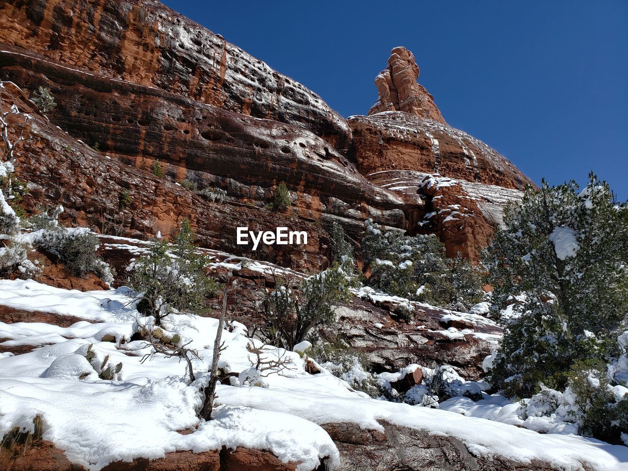 VIEW OF ROCK FORMATION ON SNOW COVERED MOUNTAIN