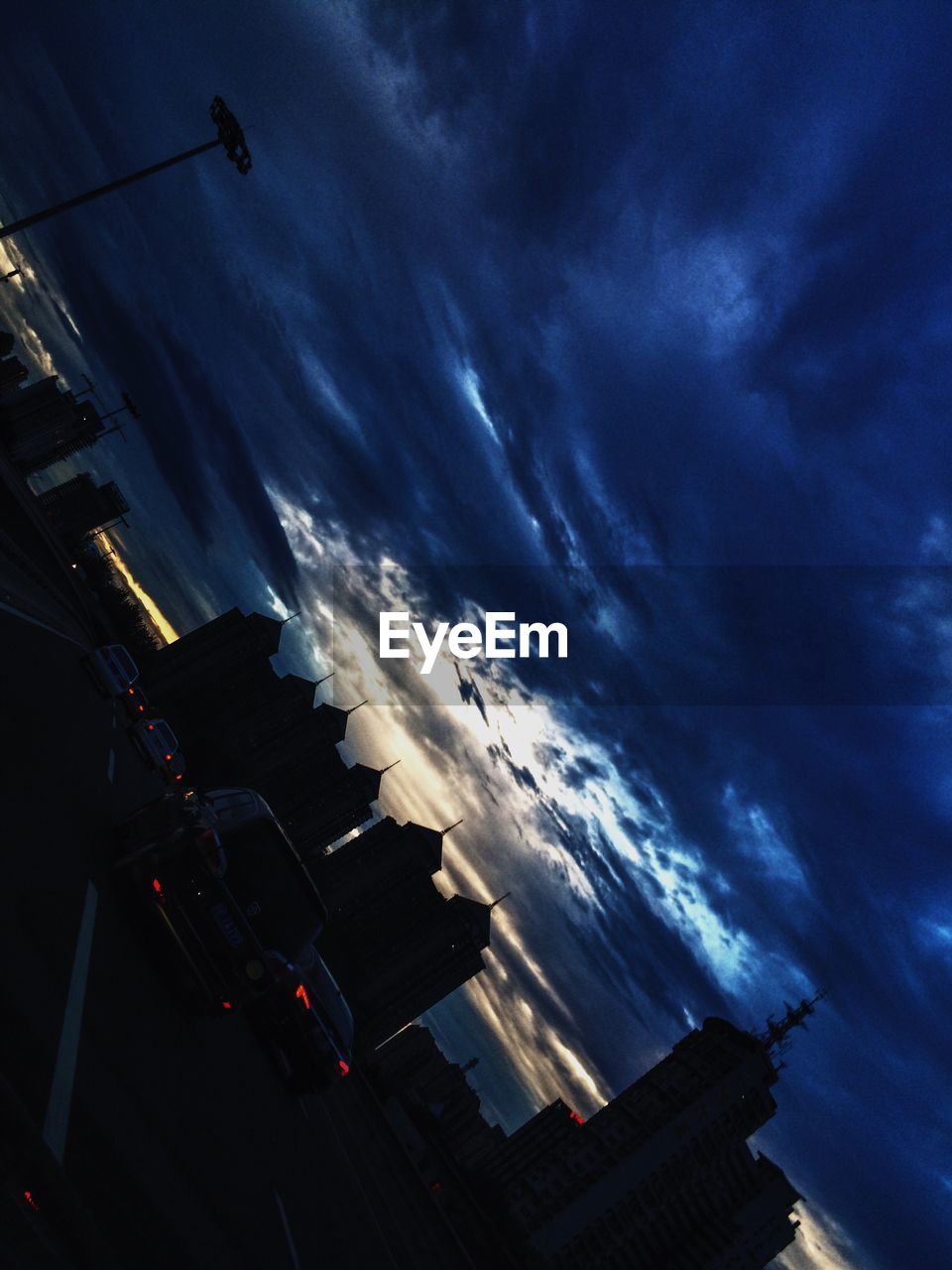 SILHOUETTE OF BUILDINGS AGAINST CLOUDY SKY