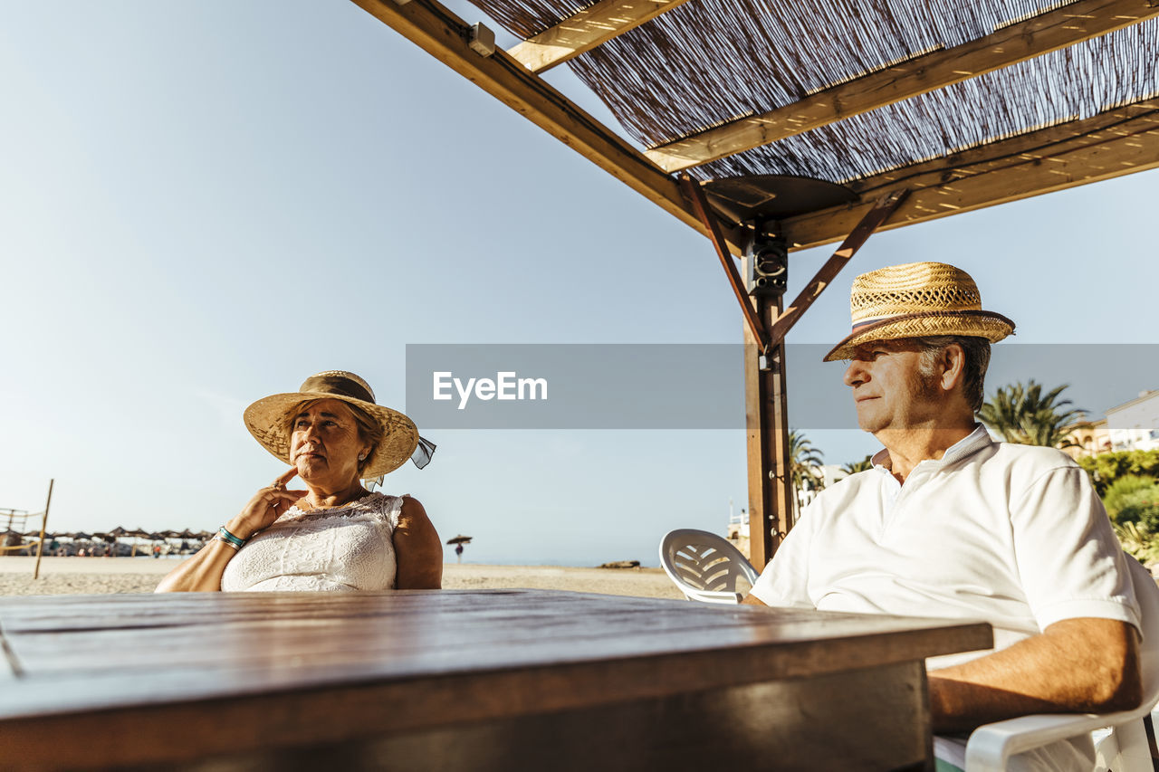 Senior couple sitting at a bar terrace at the beach, el roc de sant gaieta, spain