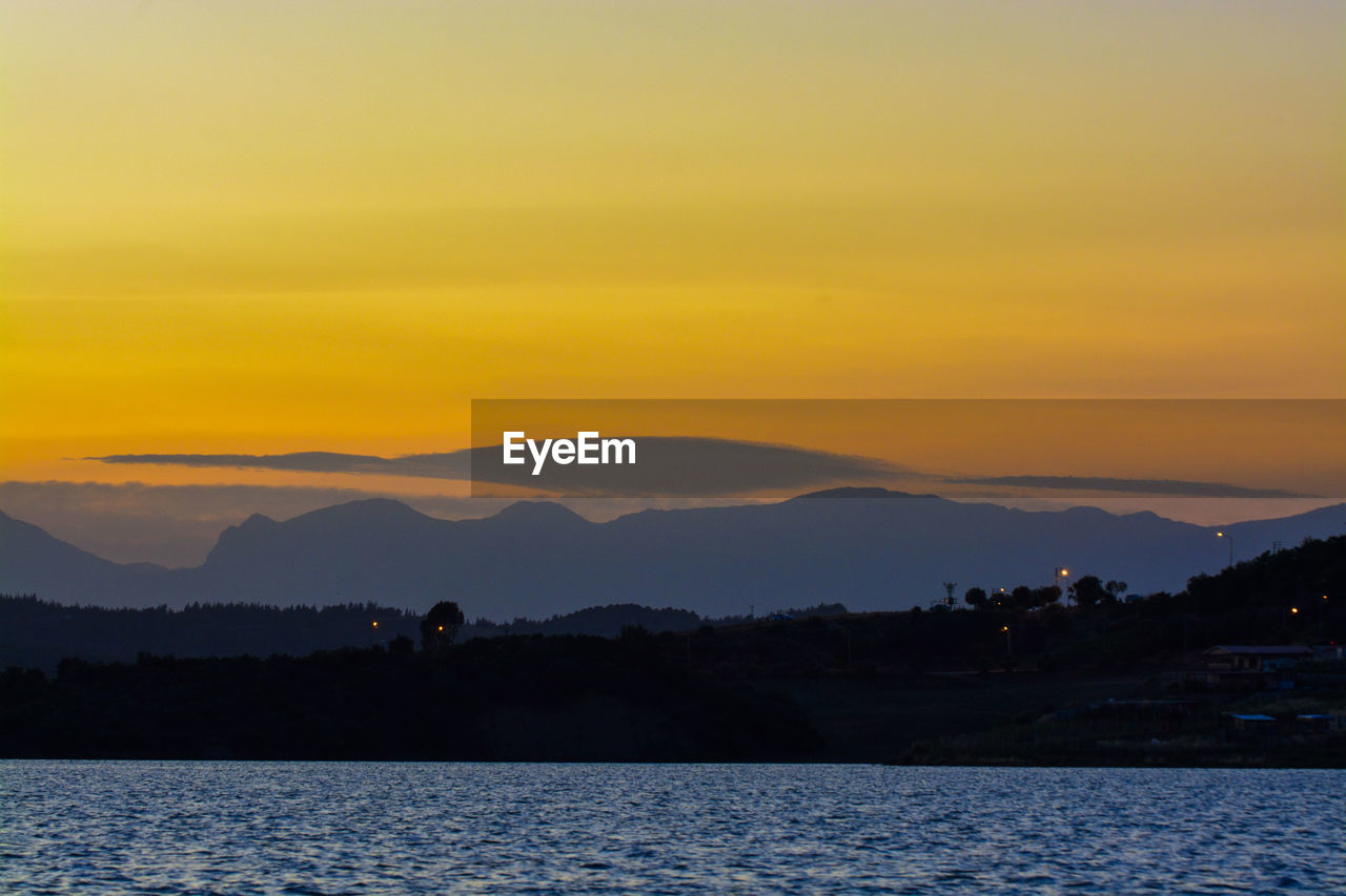 Scenic view of lake against orange sky