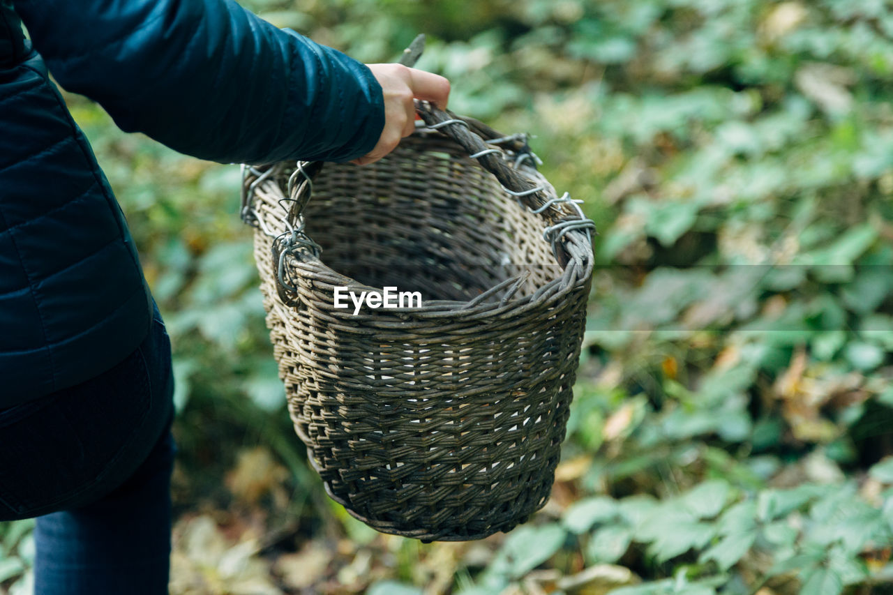 MIDSECTION OF MAN HOLDING WICKER BASKET