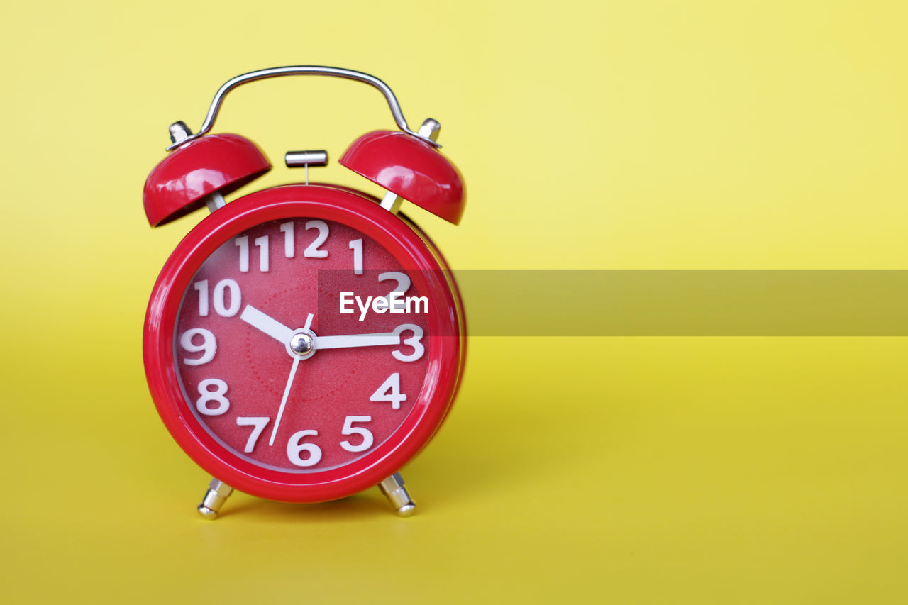 Time conceptual with word block and clock on yellow background