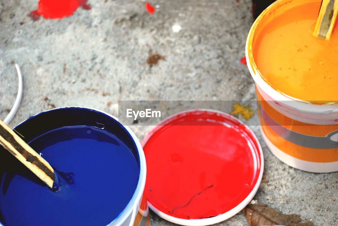 High angle view of blue and yellow paint cans