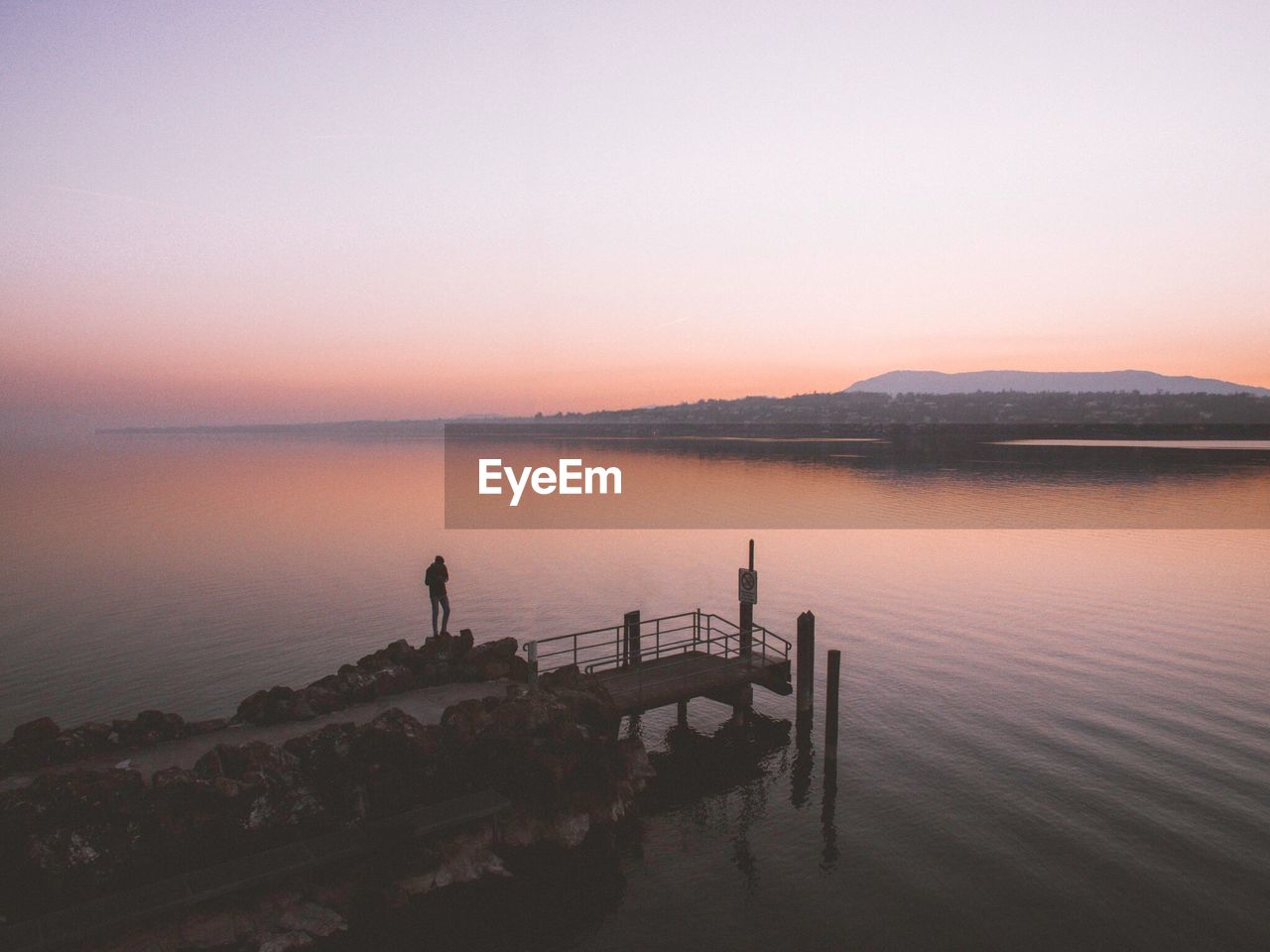 Scenic view of lake against clear sky during sunset