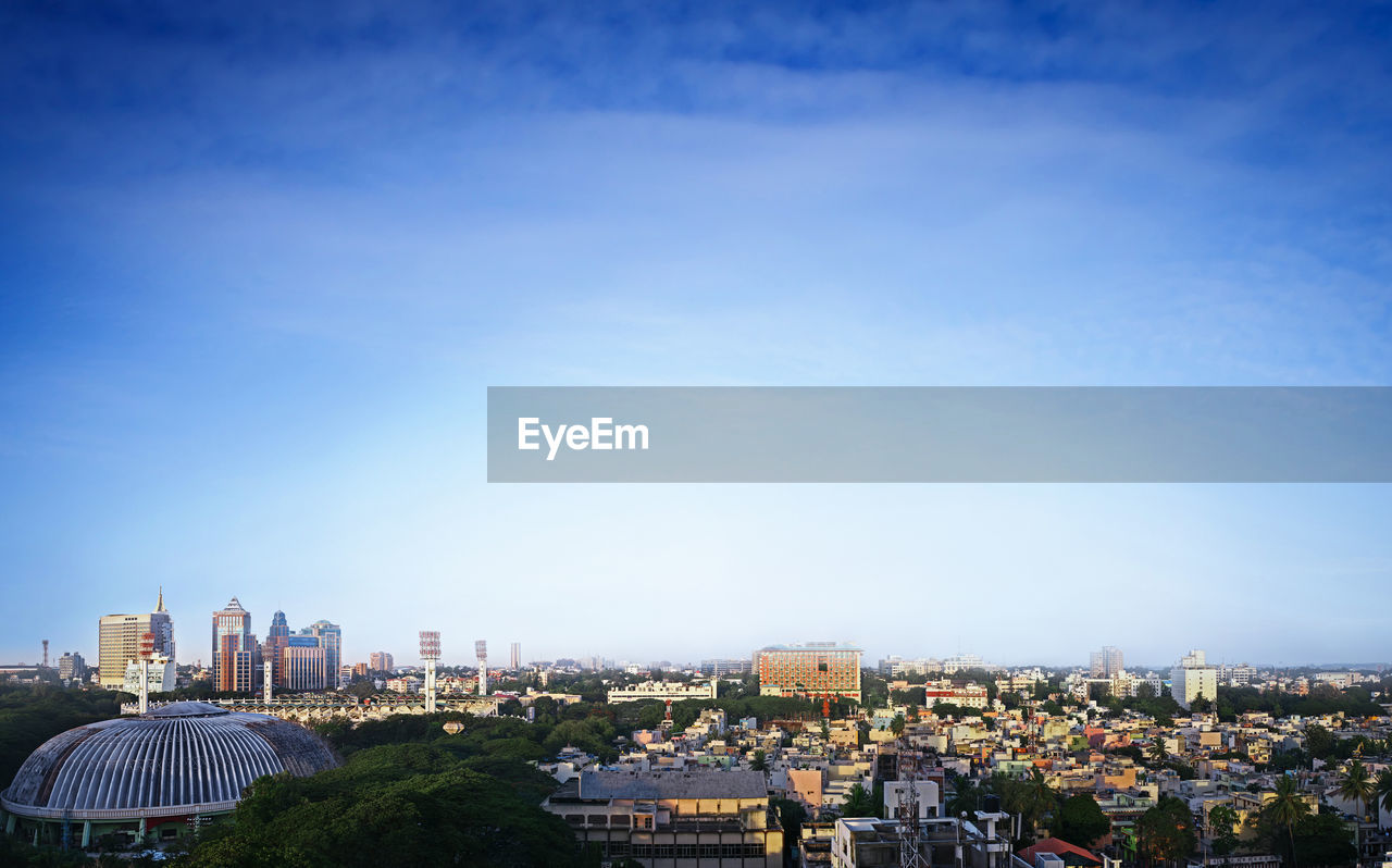 HIGH ANGLE VIEW OF MODERN BUILDINGS AGAINST BLUE SKY