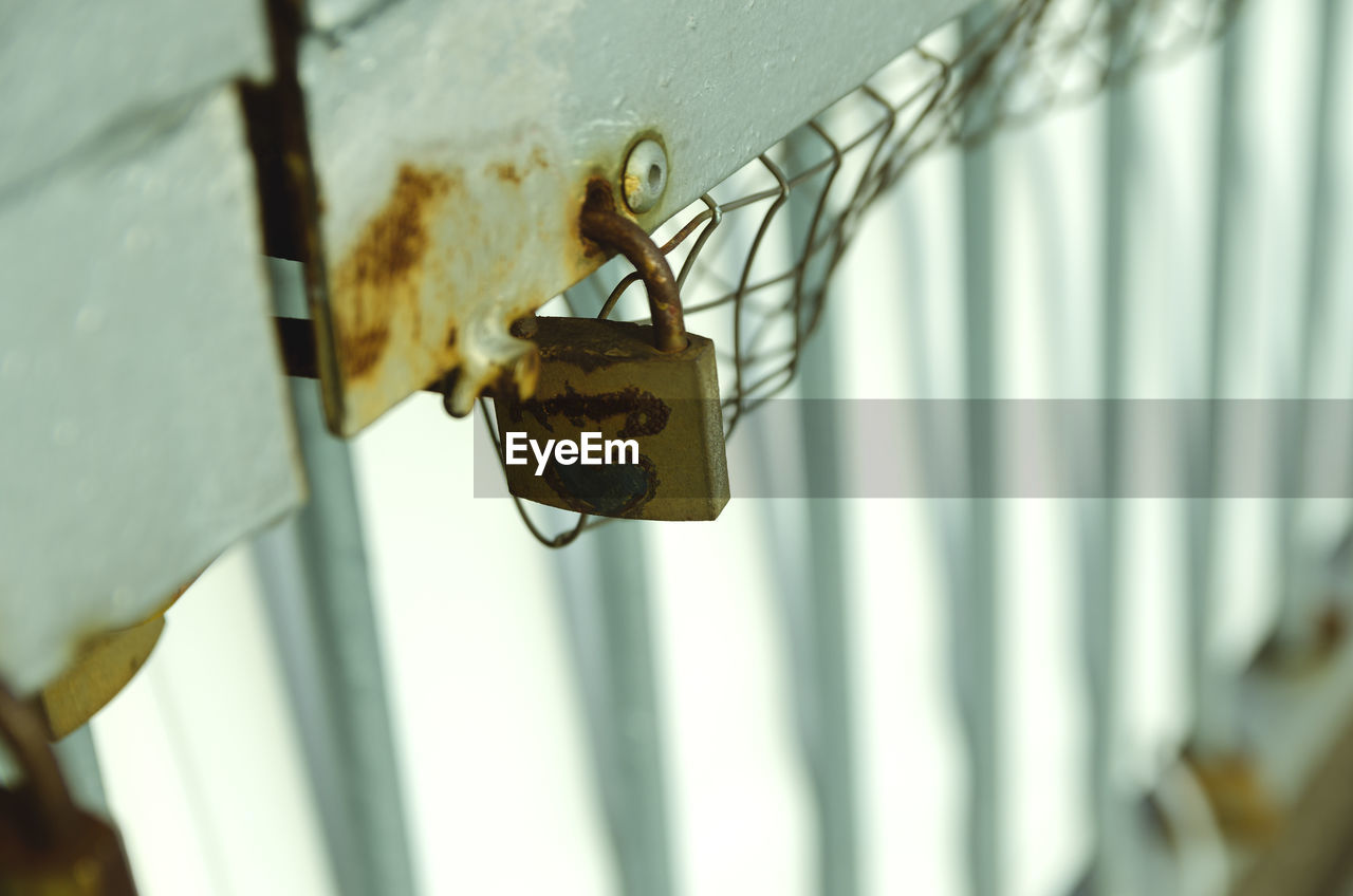 Close-up of rusty padlocks on metal railing
