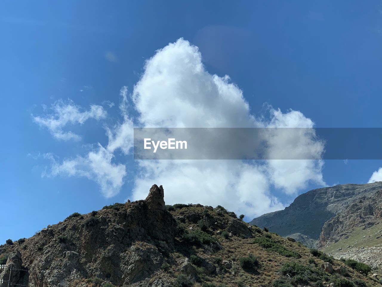 Low angle view of rocky mountain against blue sky