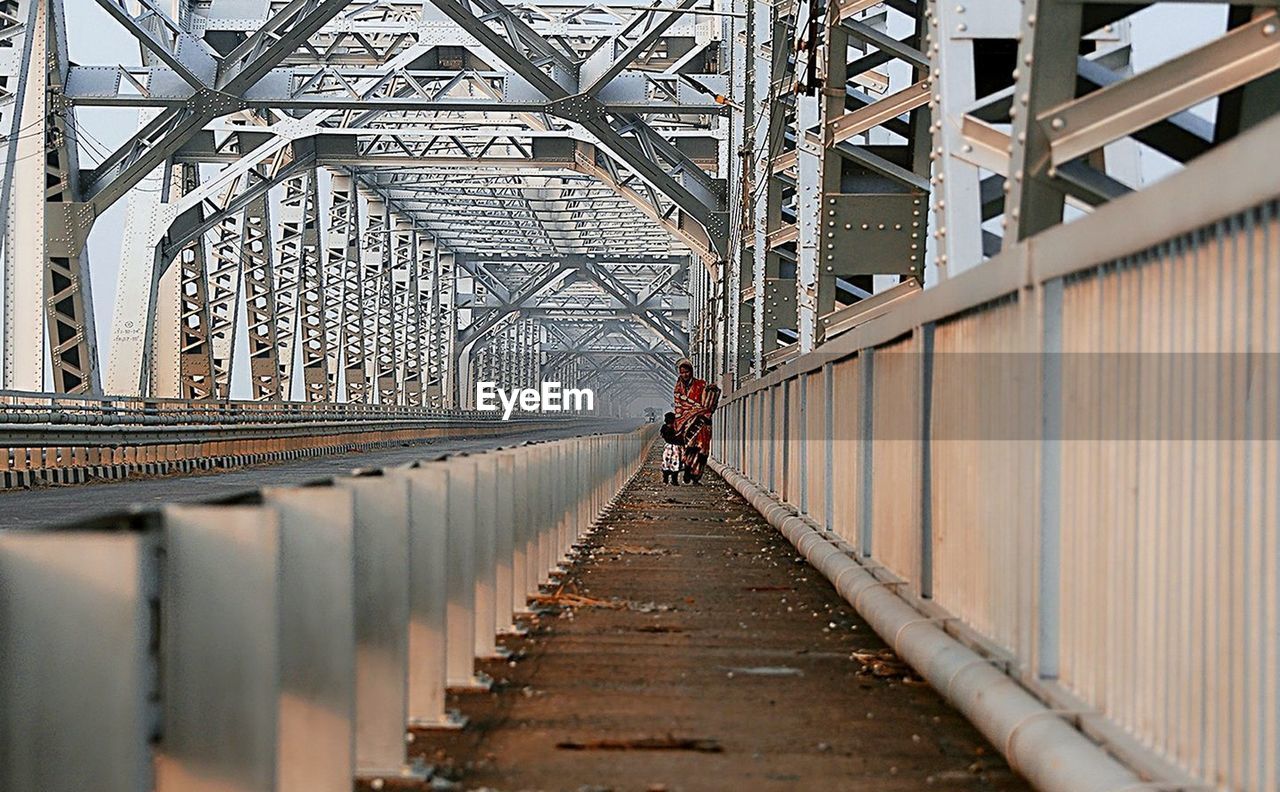 MAN WALKING ON BRIDGE