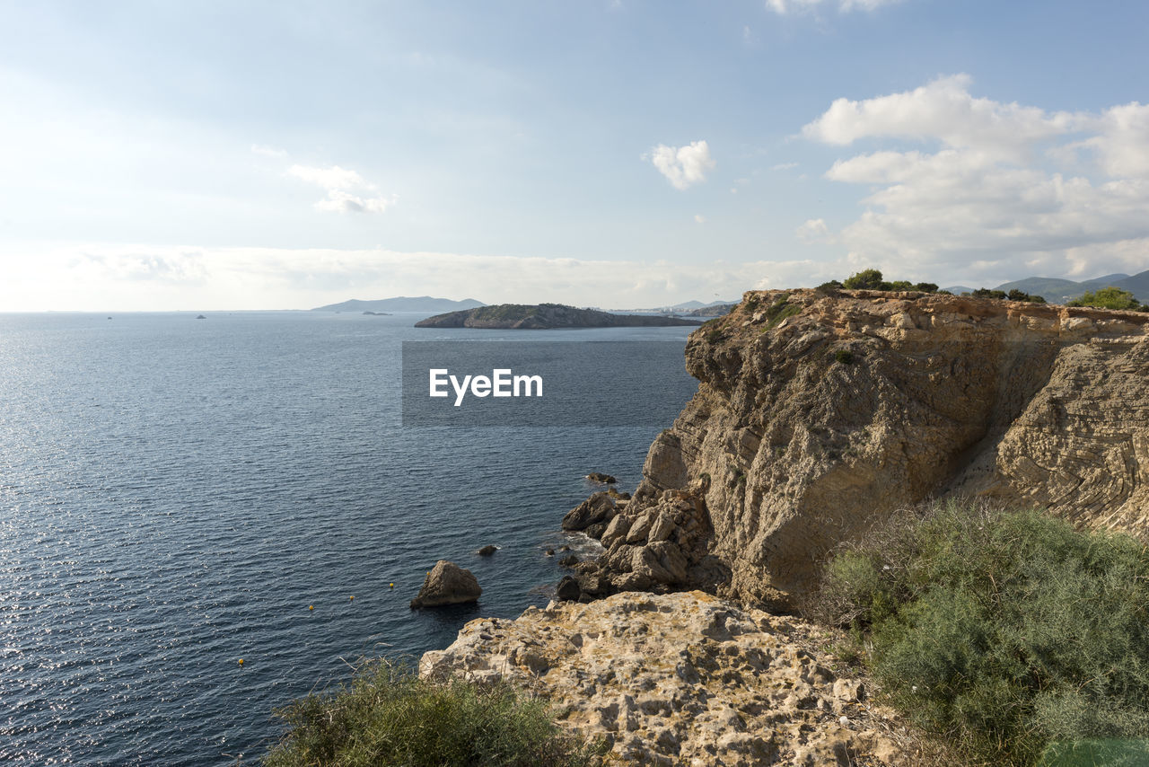 Scenic view of sea and mountains against sky