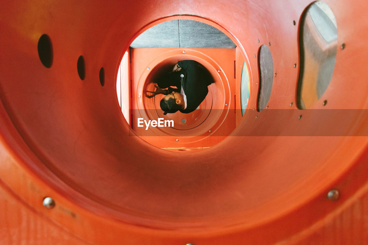 Young man sitting in pipe