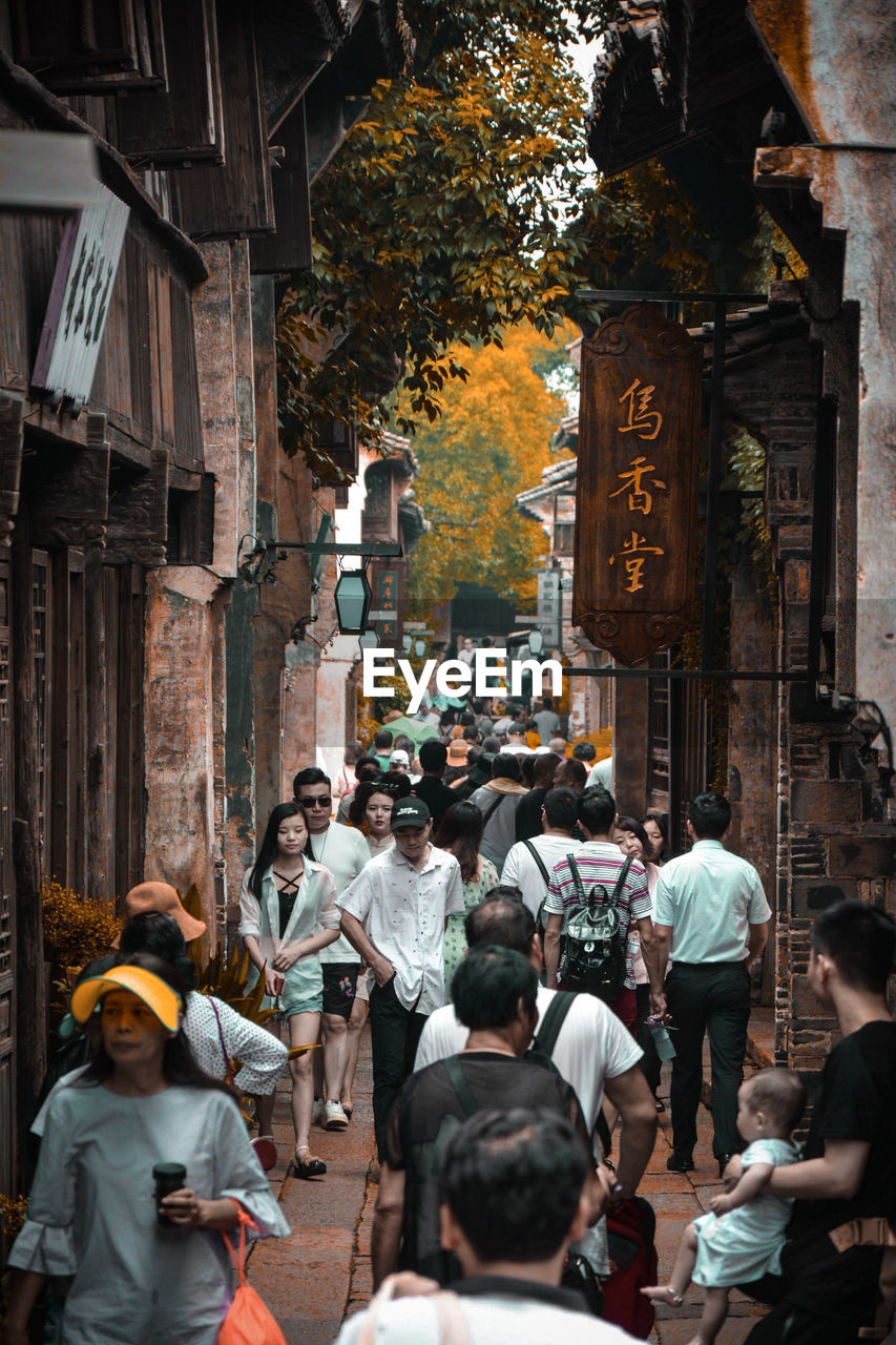 PEOPLE WALKING ON STREET IN CITY